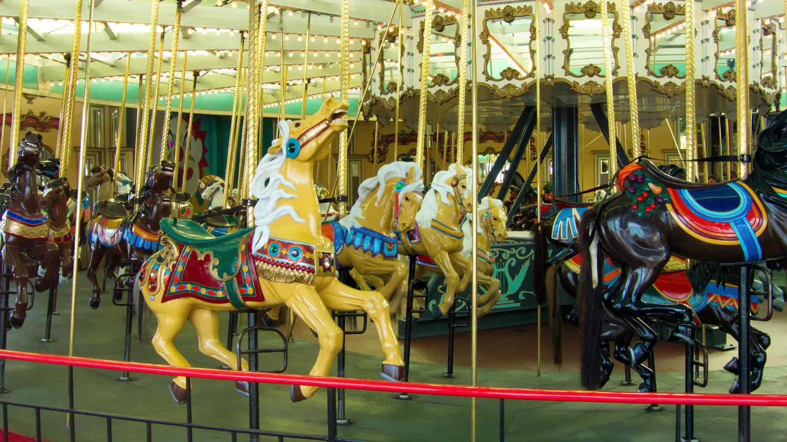 Painted horses and lights inside the historic Looff Carousel at the Santa Cruz Beach Boardwalk.